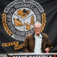 Tom Torlakson speaking with International Brotherhood emblem behind him Tom Torlakson speaking with International Brotherhood emblem behind him